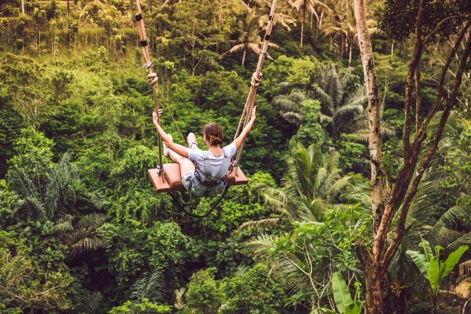 Woman Riding Hanging Swing In Forest