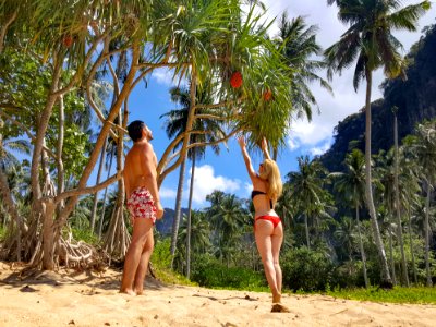 Woman Wearing Black Bikini Top And Red Bottom Beside Man Wearing White And Red Floral Shorts