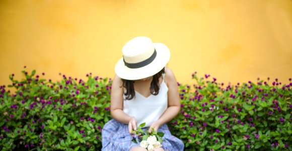 Woman Holding Bunch Of White Roses While Sitting Near Flower Fields photo