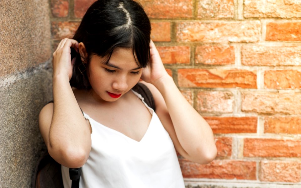 Woman Holding Her Hair While Standing On The Corner
