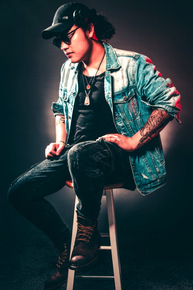 Man Wearing Denim Jacket While Sitting On Chair