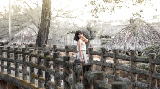Woman Wearing White Sleeveless Dress Standing On Gray Wooden Dock photo