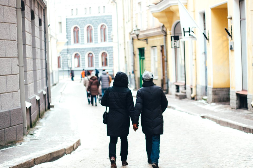 Couple Holding Hands Between Of High Rise Building At Daytime photo