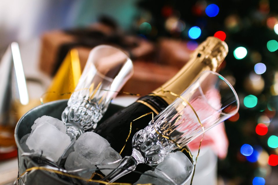 Selective Focus Photography Of Brown Labeled Bottle And Two Clear Glass Champagne Flutes photo