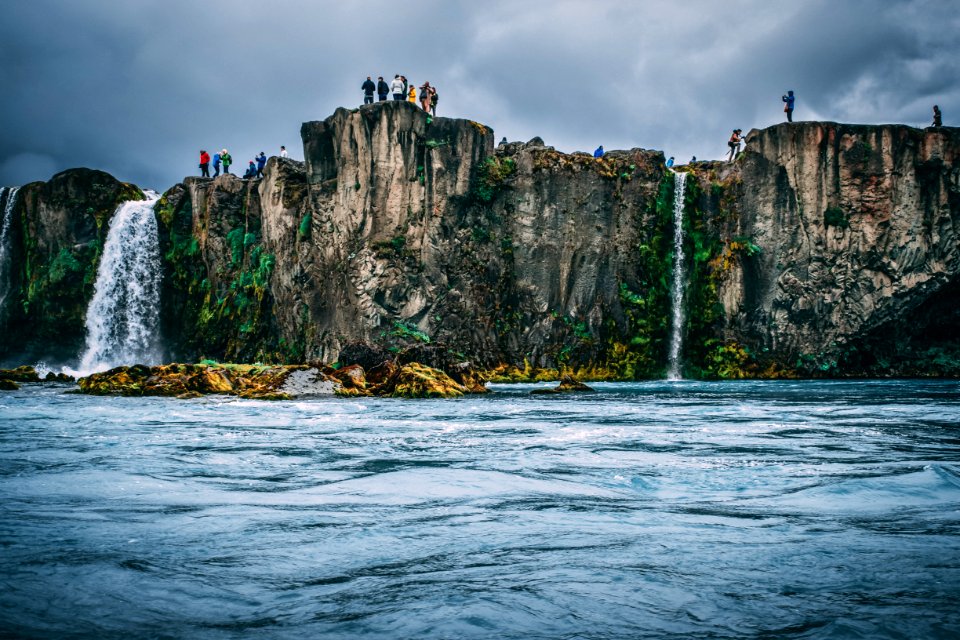 People Near Cliff Under Cloudy Sky photo