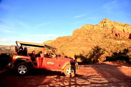 Red All-terrain Vehicle On Brown Rock Field During Sunset photo