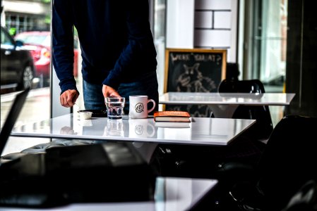 Person In Blue Long-sleeved Shirt Holding Clear Glass Cup