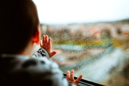 Selective Focus Photography Of A Baby Looking Through The Window photo