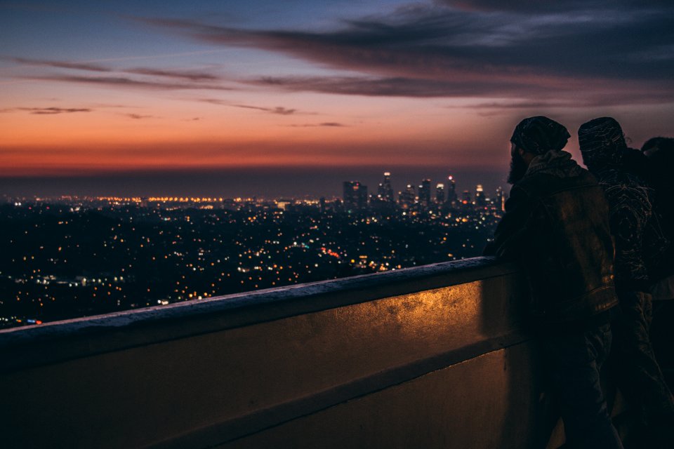 Silhouette Of People Leaning On Metal Railings