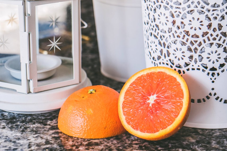 Sliced Of Orange Fruit Near On White Framed Glass Candle Lantern