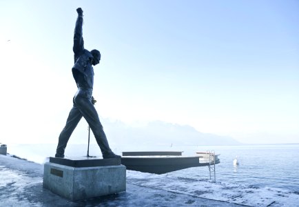 Gray Metal Statue Of Man Raising Hand Near Dock