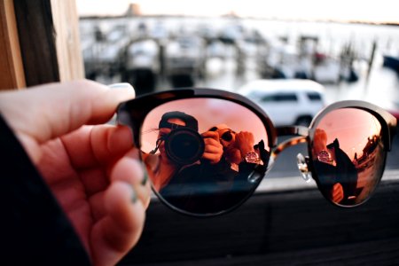 Close-Up Photography Of A Person Holding Sunglasses photo