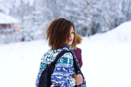 Selective Focus Portrait Photograph Of Woman Wearing Blue Green And White Tribal Jacket And Black Backpack Outfit photo