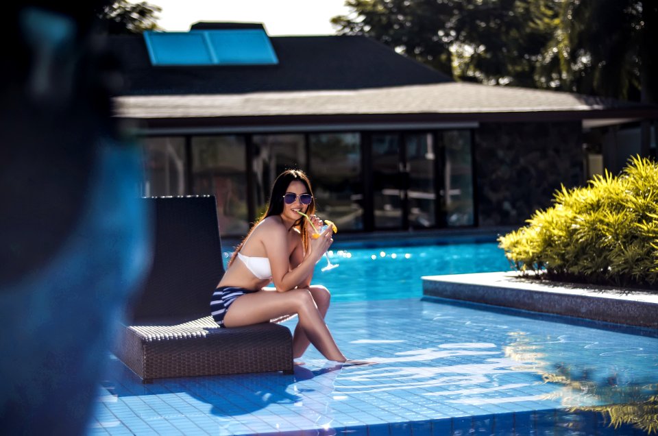 Selective Focus Photography Of Woman Wearing Black And White Bikini Sitting Brown Chair