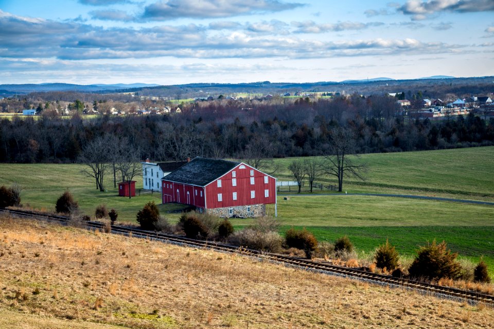 Red And Grey House In The Middle Of Green Grass Field