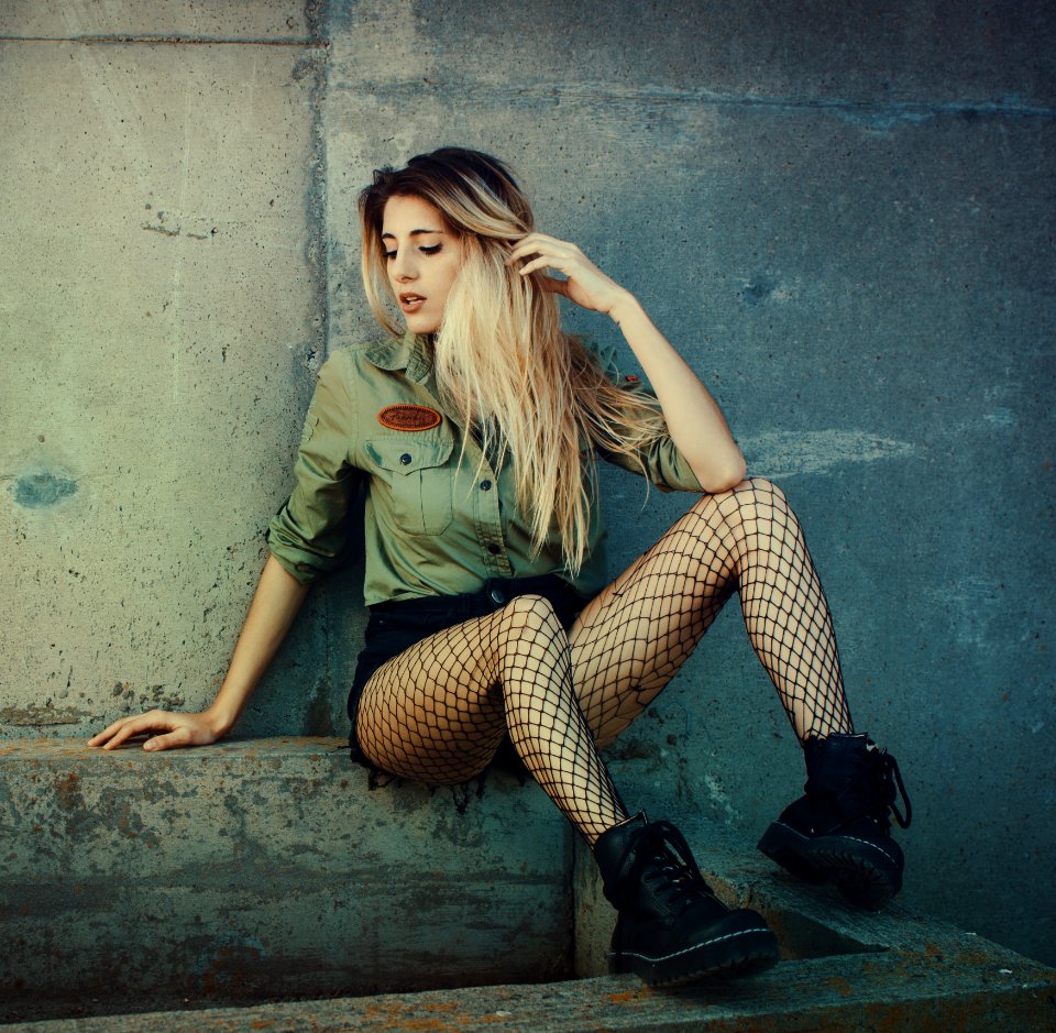 Woman Sitting On Concrete Seat While Wearing Green Button-up Long-sleeved Shirt And Mesh Stockings