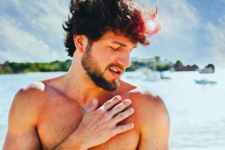 Topless Man In Front Of Body Of Water photo