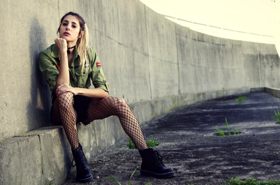 Woman Sits Besides Gray Concrete Wall photo