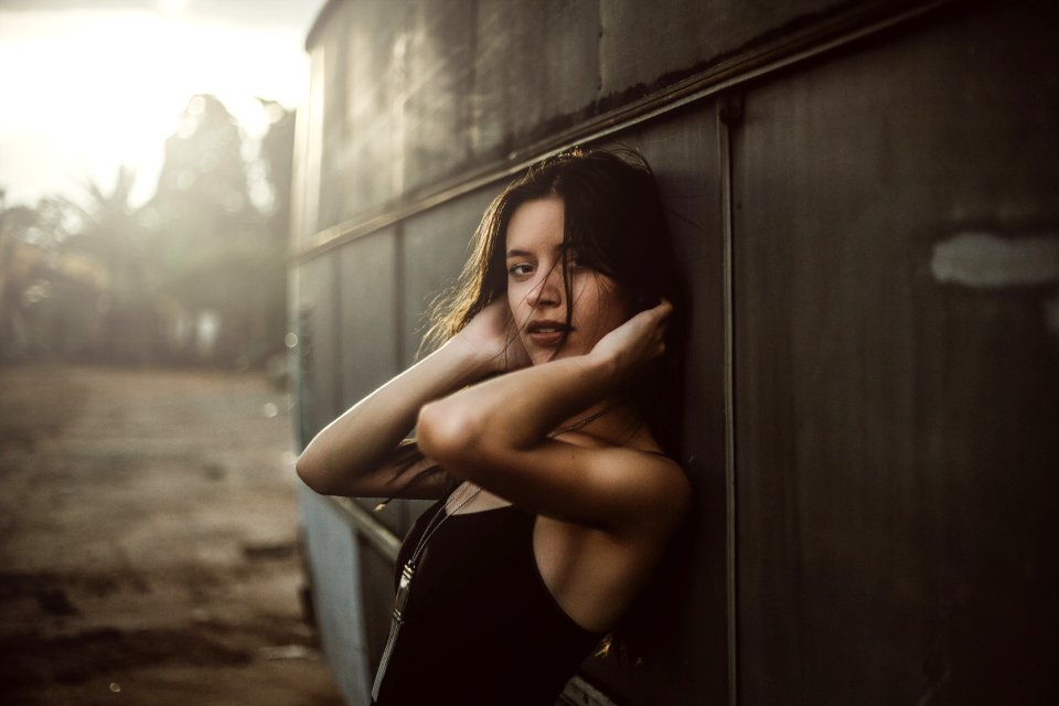 Woman In Black Spaghetti Top Holding Hair Leaning On Vehicle