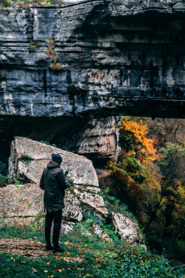 Man Standing In Front Of Rock Formation