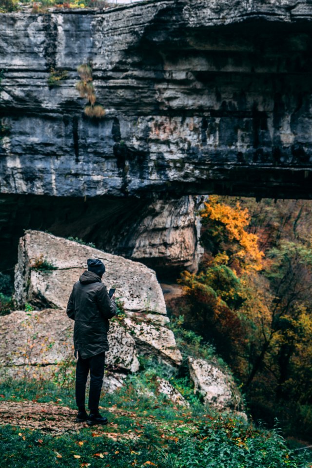 Man Standing In Front Of Rock Formation photo