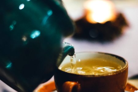 Person Pouring Liquid Into Brown Ceramic Cup photo