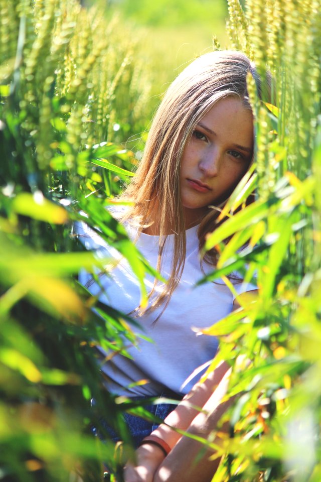 Selective Focus Photo Of Woman Wearing White Shirt Between Green Wheat