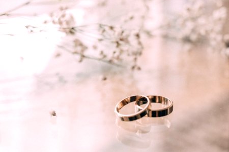 Two Silver-colored Rings On Beige Surface photo