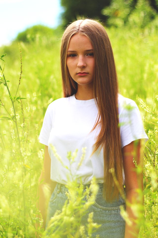 Woman Wearing White Shirt And Gray Denim Bottoms On Green Grass Field