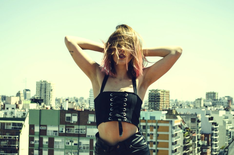Woman Holding Her Head Wearing Black Sleeveless Crop Top