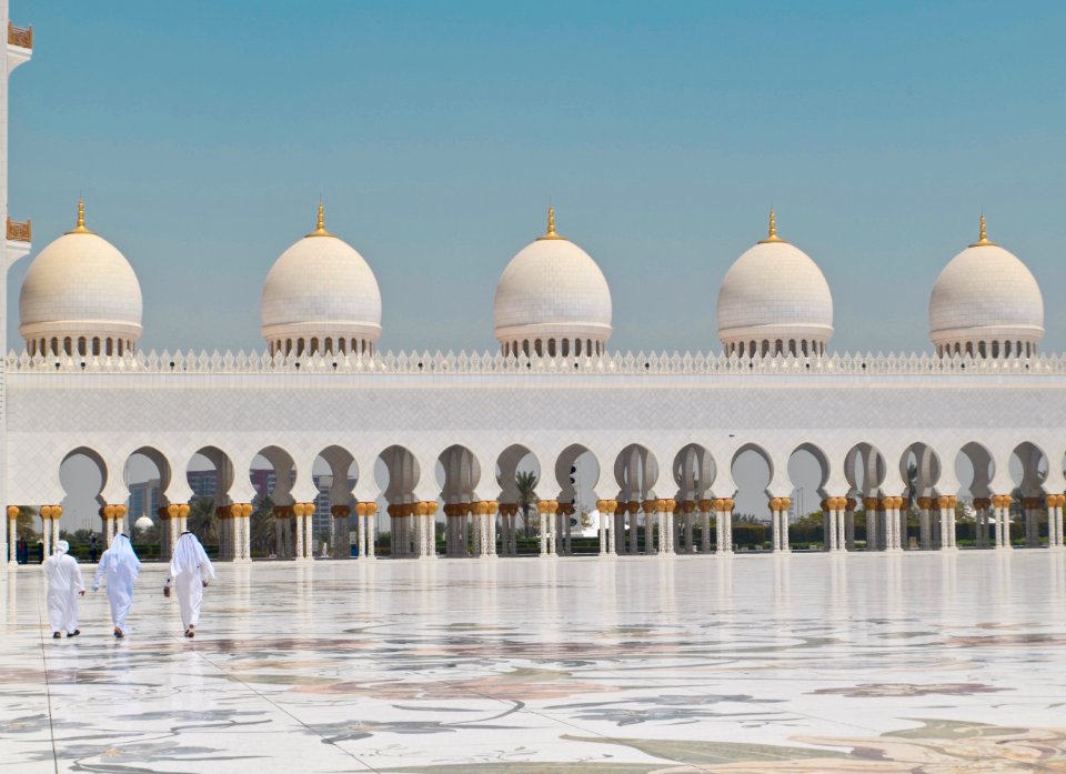 Three Men Walking In Front Of A Dome Building