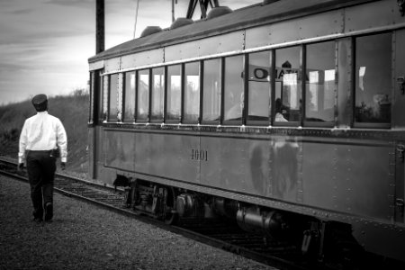 Greyscale Photography Of Train Beside Woman photo