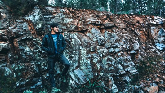 Man Wearing Jacket Standing In Stone Ledge photo