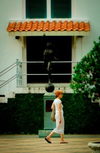 Woman Walking In Front Of Statue photo