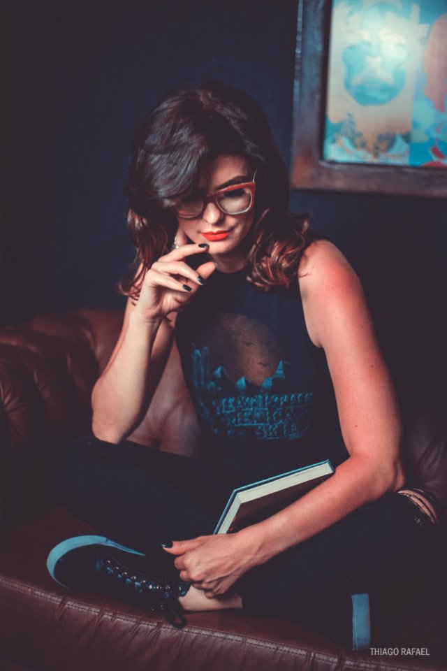 Woman Wearing Black Graphic Printed Tank Top And Pants Sitting On Brown Leather Sofa