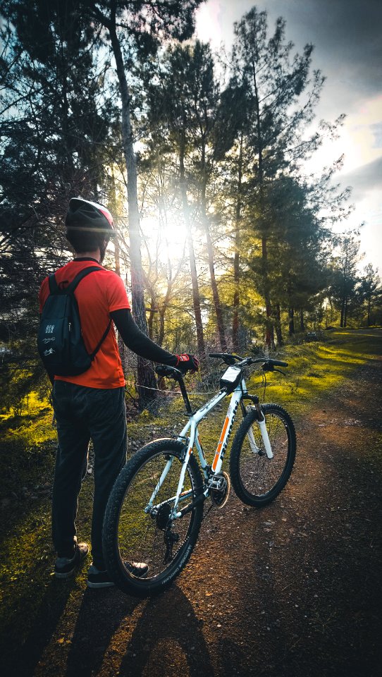 Photo Of Man Wearing Red Shirt Holding White Mountain Bike