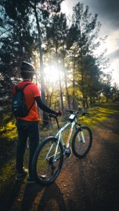 Photo Of Man Wearing Red Shirt Holding White Mountain Bike photo