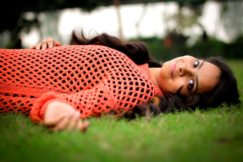 Photo Woman In Orange Long-sleeved Shirt Laying On Lawn