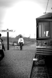 Grayscale Photo Of Man Walking Near Train photo