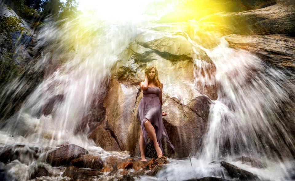 Woman In Gray Strapless Long Dress Standing Under Waterfalls photo