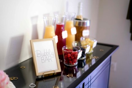 Bubbly Bar Sign With Several Assorted-color Liquid With Bottles On Top Of Black Wooden Table photo