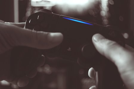 Black And White Photo Of Man Holding Sony Ps4 Wireless Controller photo