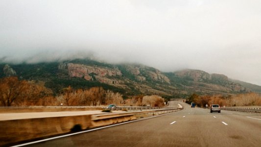 Cars On 4-lane Road Near Valley And Mountain At Daytime photo