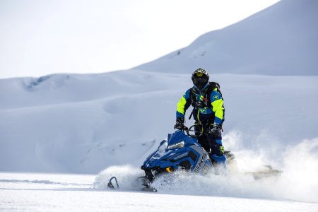 Person Rides On Blue Snowmobile At Daytime photo