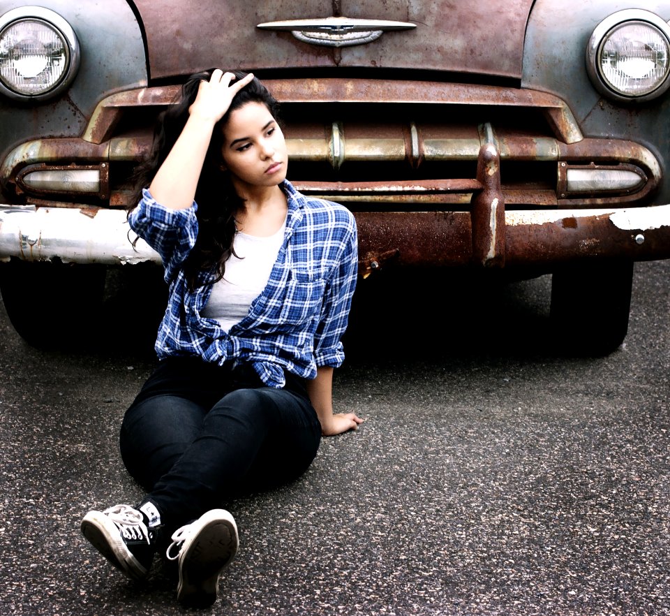 Woman In Blue Sports Shirt Sitting Infront Of Vintage Brown Car