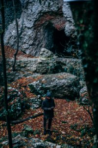 Man In Black Coat Standing Near Cave