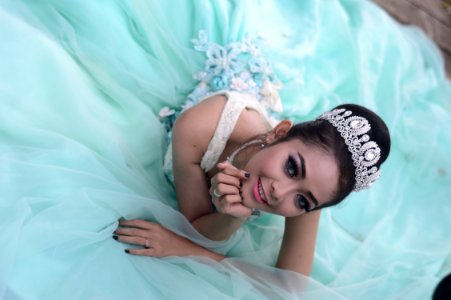 Woman Wears Teal Chiffon Gown And Crown photo