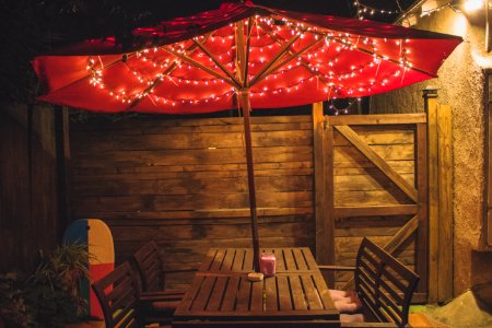 Photography Of Red Patio Table With String Lights
