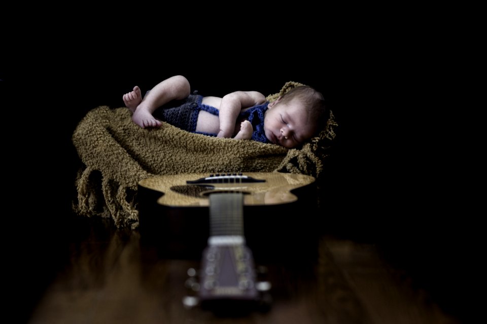 Baby On Beige Textile Near Brown Dreadnought Acoustic Guitar
