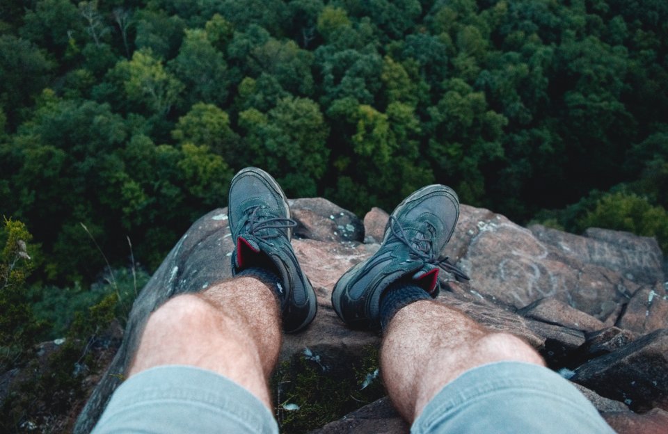 Man Standing On Edge Of Mountain